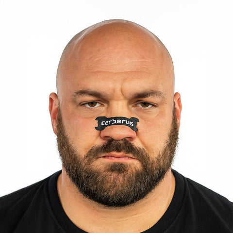 Image of Man wearing a black 'cerberus' nose strip against a white background